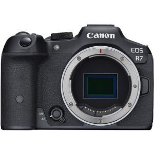 A Canon EOS R7 mirrorless camera with a black body and a mounted lens, placed on a flat surface, showcasing its sleek design and professional features.
