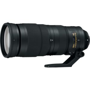 A close-up of the Nikon AF-S NIKKOR 200-500mm f/5.6E ED VR telephoto zoom lens, showcasing its large barrel, zoom ring, and gold 'NIKKOR' branding. The lens is mounted on a Nikon DSLR camera, ready for action photography.